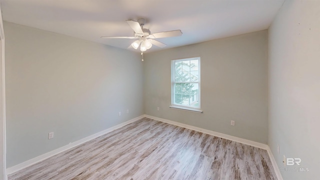 empty room featuring a ceiling fan, baseboards, and light wood finished floors