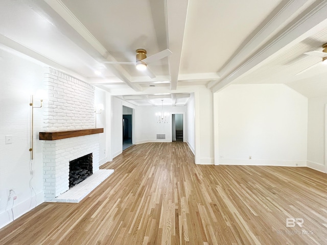 unfurnished living room with ceiling fan with notable chandelier, baseboards, a brick fireplace, and light wood-style floors