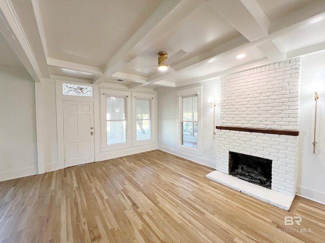 unfurnished living room with a brick fireplace, ceiling fan, coffered ceiling, beamed ceiling, and hardwood / wood-style flooring