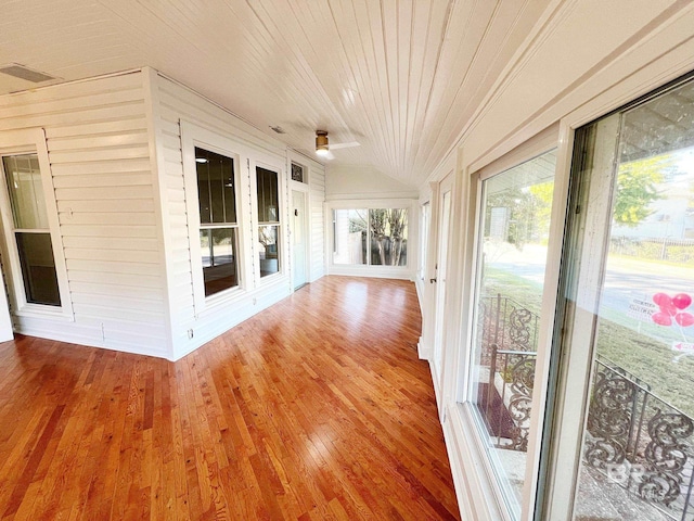 unfurnished sunroom with lofted ceiling, wooden ceiling, and wood finished floors