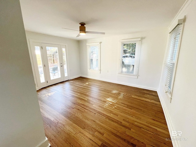 empty room with ceiling fan, baseboards, ornamental molding, and wood finished floors