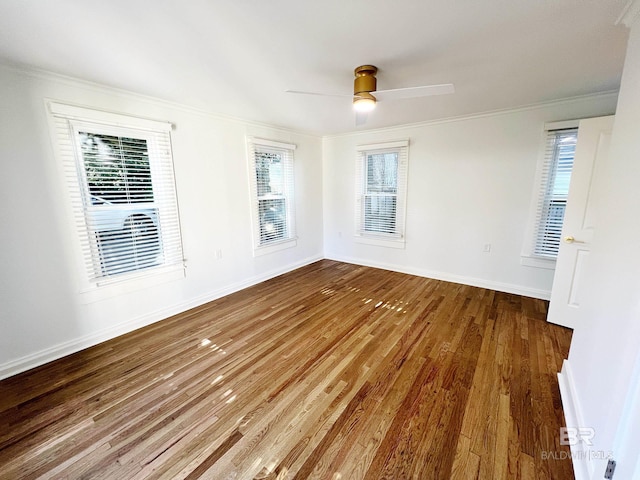 unfurnished room featuring wood finished floors, a healthy amount of sunlight, crown molding, and a ceiling fan
