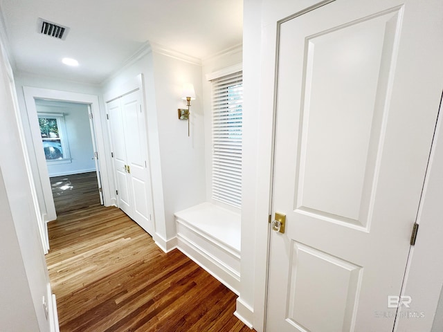 mudroom with wood finished floors, visible vents, crown molding, and baseboards
