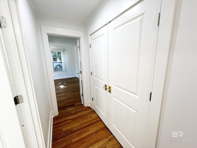 hall with dark wood-type flooring and ornamental molding