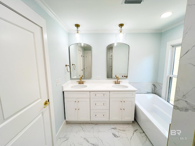 full bathroom with double vanity, a freestanding tub, crown molding, and a sink