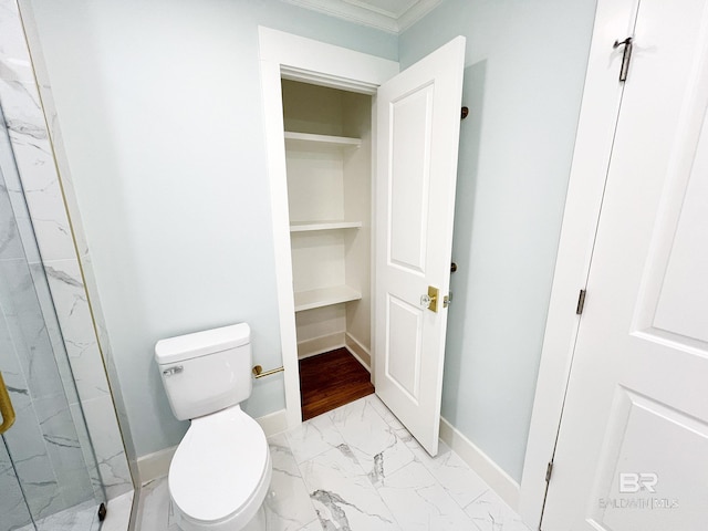 bathroom with marble finish floor, toilet, a marble finish shower, ornamental molding, and baseboards