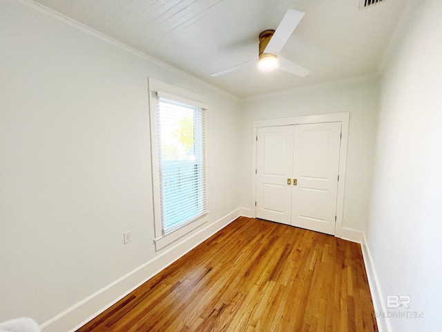 unfurnished bedroom featuring ornamental molding, a closet, light hardwood / wood-style floors, and ceiling fan