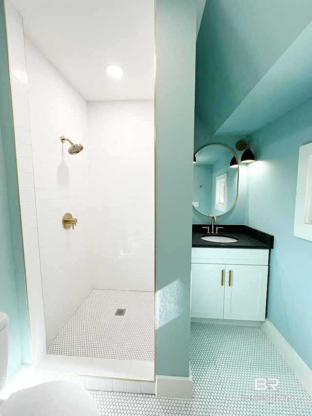 bathroom with vanity, a tile shower, tile patterned floors, and toilet