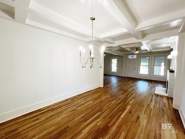 unfurnished dining area featuring a fireplace, hardwood / wood-style floors, coffered ceiling, beam ceiling, and ornamental molding