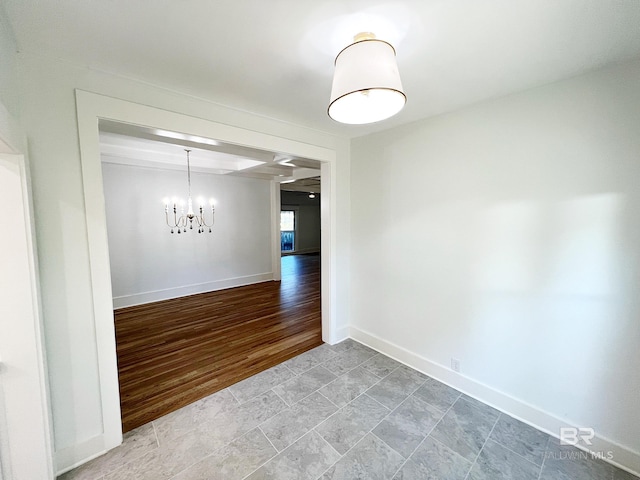 unfurnished dining area with baseboards, an inviting chandelier, and light wood-style floors