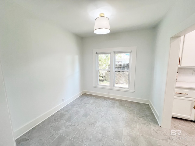 unfurnished dining area featuring baseboards