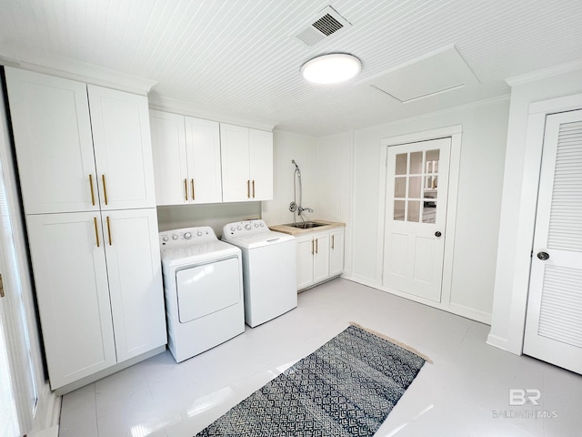laundry area featuring attic access, visible vents, separate washer and dryer, cabinet space, and ornamental molding