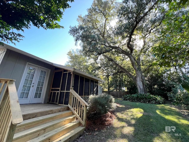 view of yard featuring fence, a sunroom, and french doors