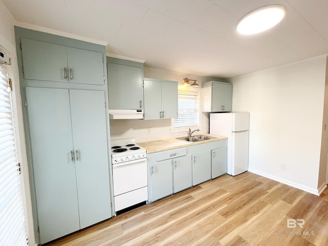 kitchen with light wood finished floors, a sink, white appliances, light countertops, and under cabinet range hood