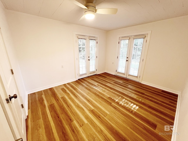 empty room featuring baseboards, a ceiling fan, french doors, and light wood finished floors