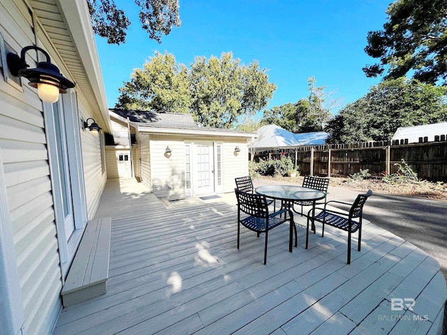wooden deck with outdoor dining space and fence