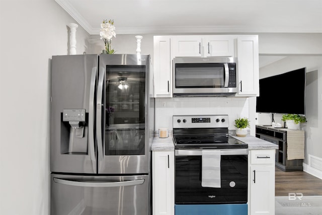 1508 Phillips Ln, Mobile, AL 36618 - kitchen featuring appliances with stainless steel finishes, white cabinetry, tasteful backsplash, dark wood-style flooring, and crown molding