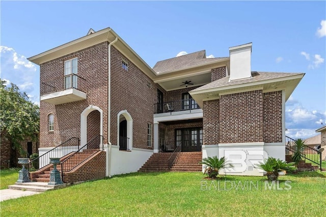 back of house with a yard, a balcony, and ceiling fan