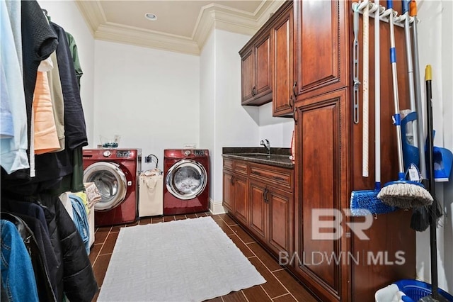 clothes washing area featuring cabinets, ornamental molding, separate washer and dryer, and sink