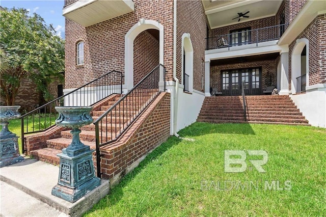 doorway to property with ceiling fan, a yard, french doors, and a balcony