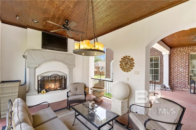 interior space featuring ceiling fan and an outdoor living space with a fireplace