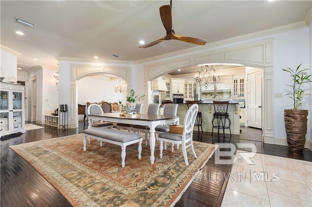 dining room with crown molding and ceiling fan with notable chandelier