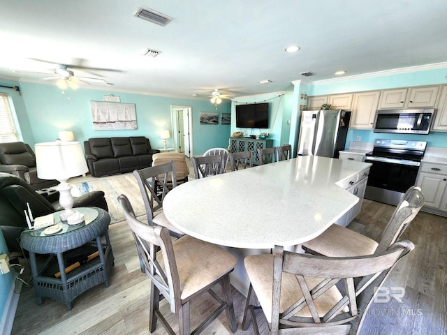 dining area with crown molding, light hardwood / wood-style flooring, and ceiling fan