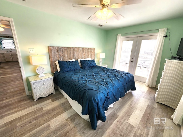 bedroom featuring ceiling fan, access to exterior, hardwood / wood-style floors, and french doors