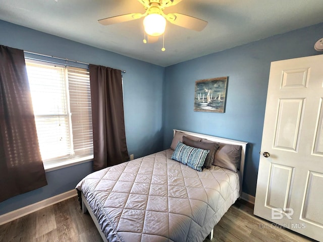 bedroom with ceiling fan, multiple windows, and wood-type flooring