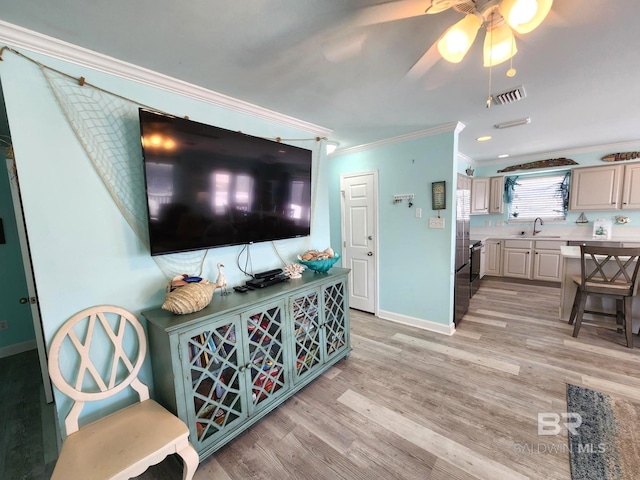 living room with sink, ceiling fan, light hardwood / wood-style flooring, and crown molding