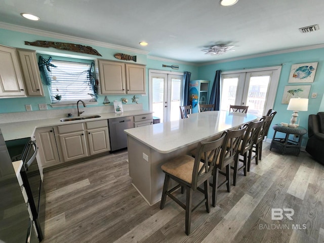 kitchen with sink, stainless steel dishwasher, a center island, and french doors