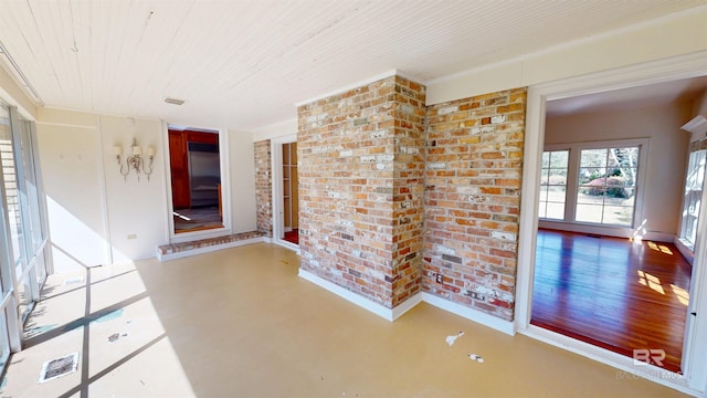 corridor featuring wooden ceiling, finished concrete floors, and brick wall