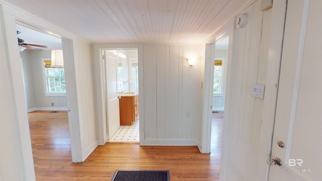 corridor with visible vents, light wood-style flooring, wood ceiling, and baseboards