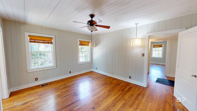 spare room featuring visible vents, baseboards, wooden ceiling, wood finished floors, and a ceiling fan