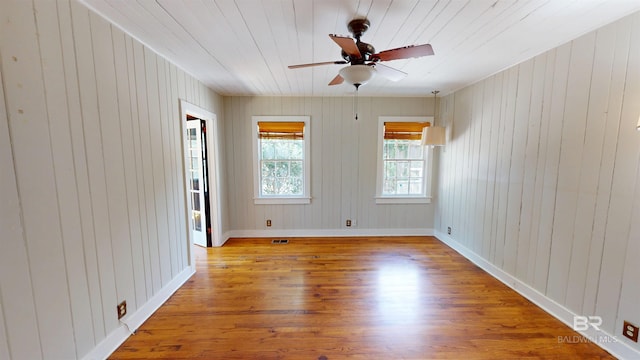 empty room with visible vents, wood finished floors, wooden ceiling, baseboards, and ceiling fan