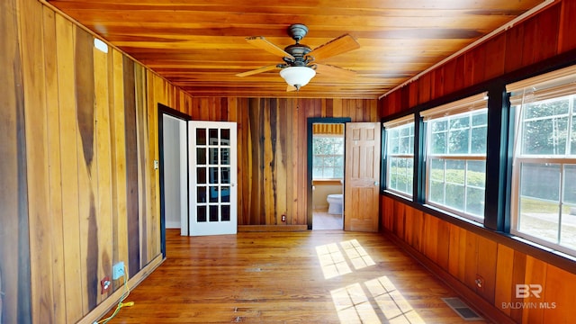 unfurnished sunroom with wooden ceiling, visible vents, and ceiling fan