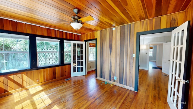 empty room featuring visible vents, a healthy amount of sunlight, wood ceiling, and wood finished floors