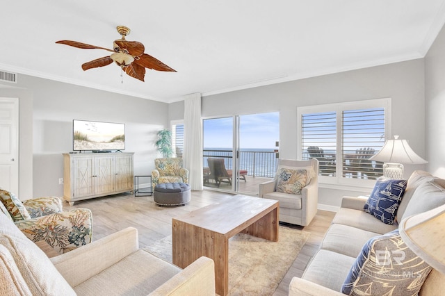 living area with crown molding, light wood-style flooring, plenty of natural light, and a ceiling fan