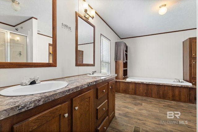 19300 Community Ln, Summerdale, AL 36580 - full bathroom featuring crown molding, a shower stall, a garden tub, double vanity, and wood finished floors