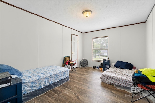 19300 Community Ln, Summerdale, AL 36580 - bedroom featuring crown molding, wood finished floors, a textured ceiling, and a decorative wall
