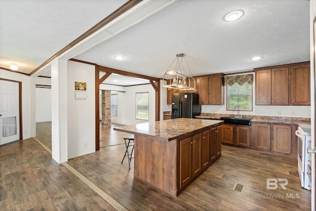 19300 Community Ln, Summerdale, AL 36580 - kitchen with black refrigerator with ice dispenser, a sink, a kitchen island, crown molding, and healthy amount of natural light