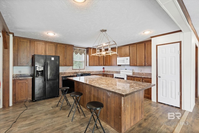 19300 Community Ln, Summerdale, AL 36580 - kitchen featuring white appliances, brown cabinets, dark wood-style floors, a center island, and a textured ceiling