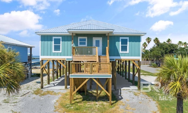 beach home featuring covered porch and a carport