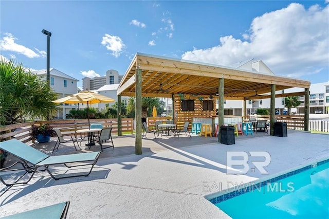 view of property's community featuring a pool, fence, and a patio