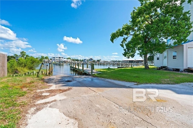 view of front of home featuring a front lawn, a dock, and a water view