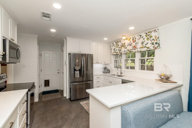 6000 Shenandoah Rd, Mobile, AL 36608 - kitchen featuring appliances with stainless steel finishes, a sink, a peninsula, white cabinetry, and light countertops
