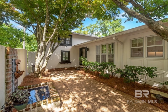 6000 Shenandoah Rd, Mobile, AL 36608 - rear view of house with stucco siding, fence, and a patio