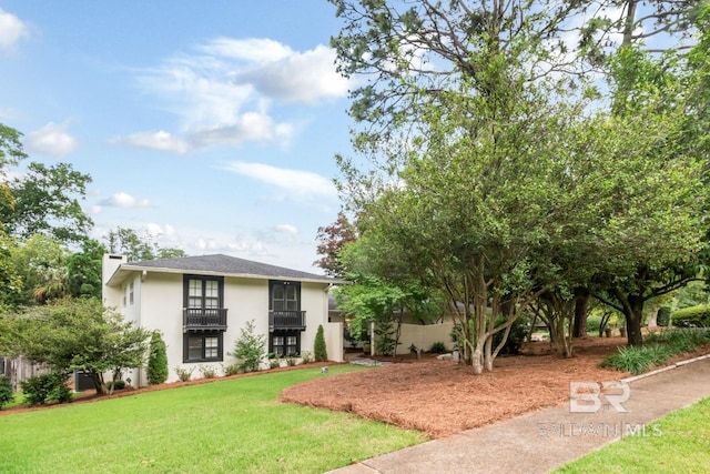 6000 Shenandoah Rd, Mobile, AL 36608 - view of front facade featuring a front yard, stucco siding, a balcony, and a chimney