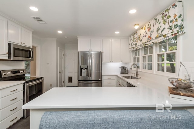 6000 Shenandoah Rd, Mobile, AL 36608 - kitchen with appliances with stainless steel finishes, a sink, recessed lighting, light countertops, and white cabinets