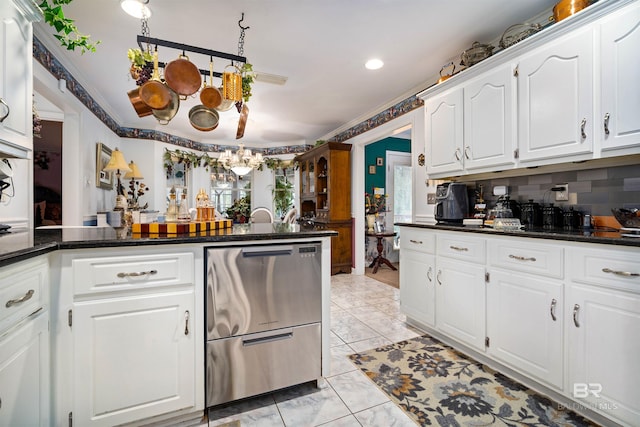 kitchen with white cabinetry, backsplash, crown molding, and kitchen peninsula